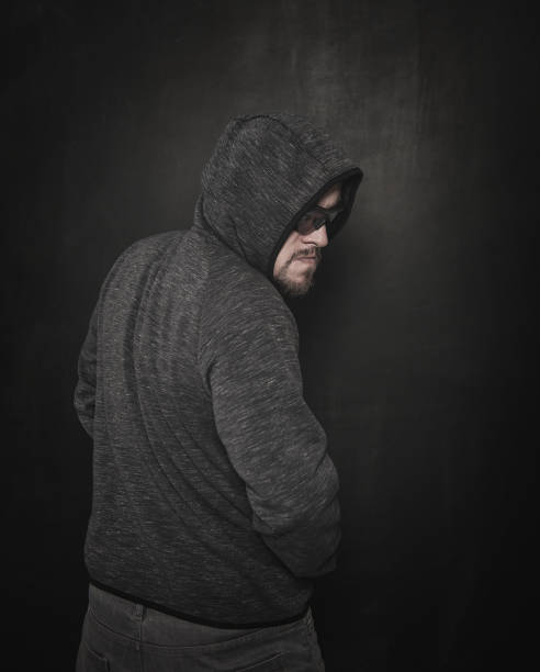 istock Mystery unknown man in hood on dark 1166803922