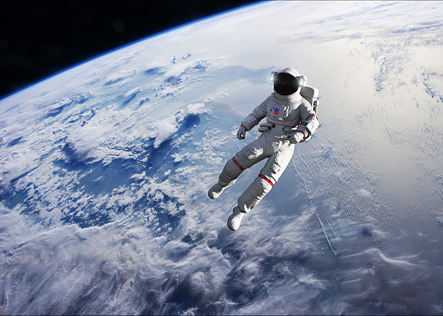 Asian chinese mid adult female astronaut looking at earth through window from spaceship at outer space