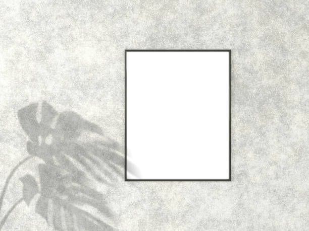 istock 4x5 vertical Black frame for photo or picture mockup on concrete background with shadow of monstera leaves. 3D rendering. 1166807083