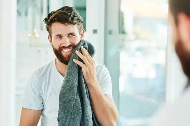 Cropped shot of a young man drying his beard with a towel