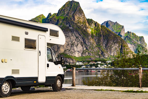 Camper car on fjord, Lofoten Norway Camper car motor home and fjord landscape with Reine village in summer, Lofoten Norway. Camping on nature. Holidays and travel in caravan. RV truck stock pictures, royalty-free photos & images