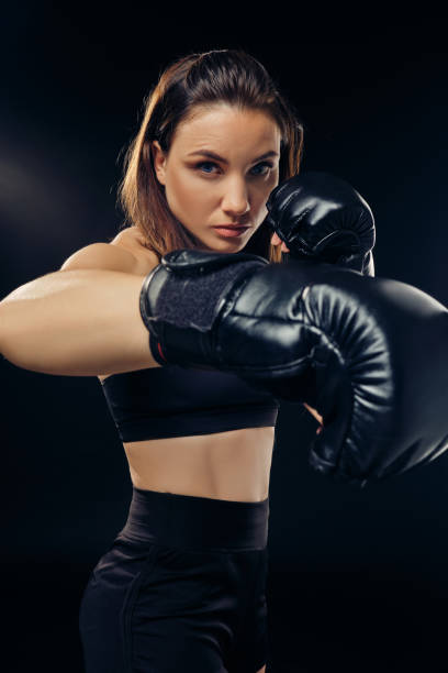 istock Athletic woman in boxing gloves is practicing karate in studio 1166808814