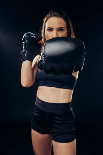 istock Athletic woman in boxing gloves is practicing karate in studio 1166808891