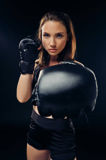 istock Athletic woman in boxing gloves is practicing karate in studio 1166809482