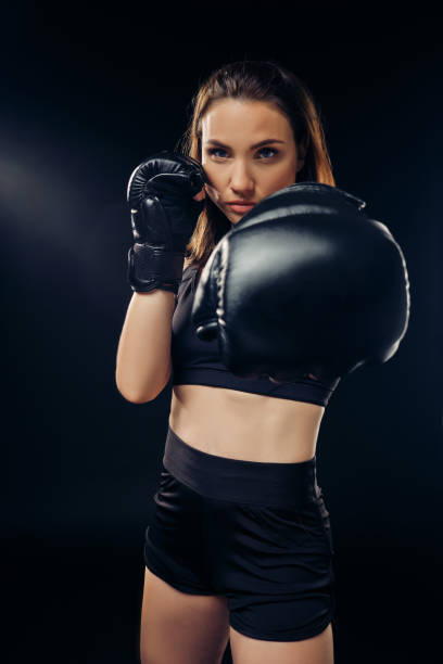 istock Athletic woman in boxing gloves is practicing karate in studio 1166809587