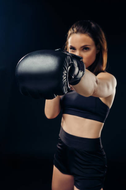istock Athletic woman in boxing gloves is practicing karate in studio 1166809663