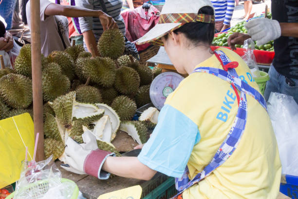 frau schneidet durian obst auf khong toei nassen markt in bangkok, thailand - khlong toei stock-fotos und bilder
