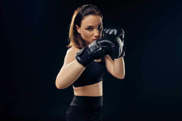 istock Athletic woman in boxing gloves is practicing karate in studio 1166809736