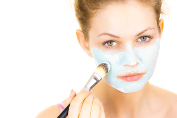 istock Girl apply green mud mask to face 1166809748