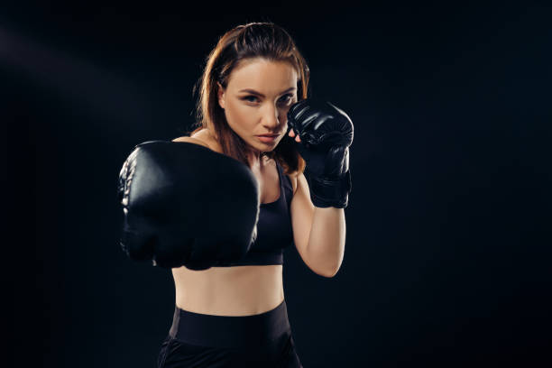 istock Athletic woman in boxing gloves is practicing karate in studio 1166809778