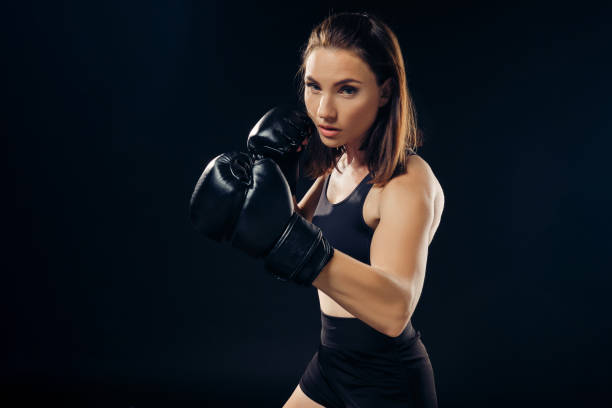 istock Athletic woman in boxing gloves is practicing karate in studio 1166809871