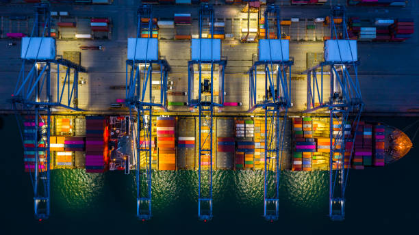 istock Container ship working at night, Business import export logistic and transportation of International by container ship in the open sea, Aerial view container ship loading and unloading at night. 1166811272