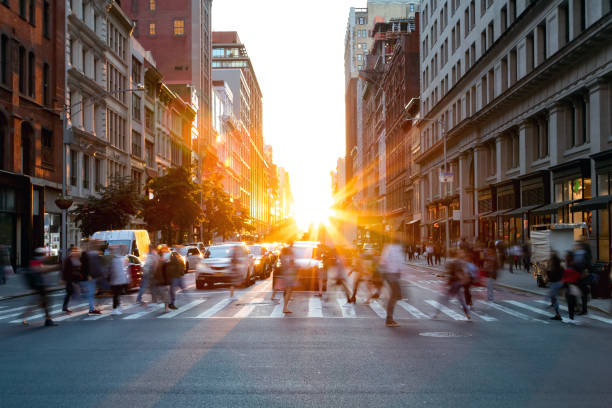 Crowds of busy people walking through the intersection of 5th Avenue and 23rd Street in Manhattan, New York City Crowds of busy people walking through the intersection of 5th Avenue and 23rd Street in Manhattan, New York City with bright sunset background crosswalk stock pictures, royalty-free photos & images