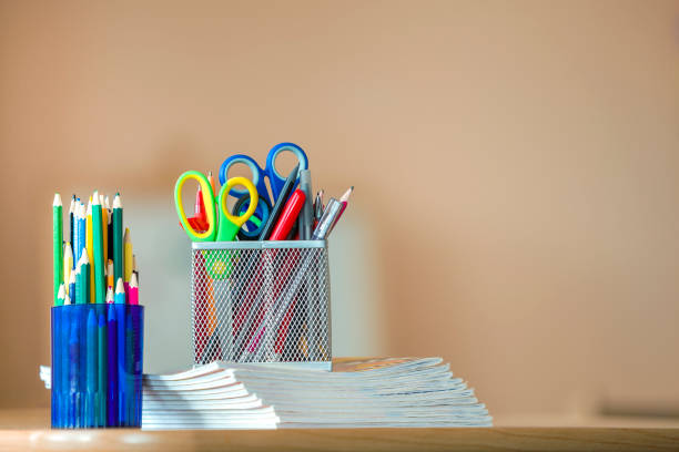 istock Stack of notebooks, colorful drawing pencils and stationery arrangement on copy space background. 1166813180