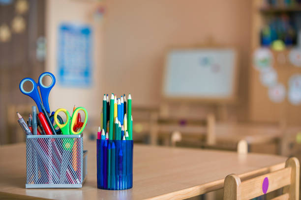 istock Stack of notebooks, colorful drawing pencils and stationery arrangement on copy space background. 1166813188