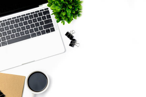istock Modern white office desk table with laptop computer, smartphone with black screen over a notebook and cup of coffee. 1166814518
