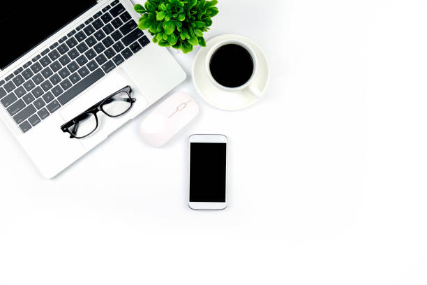 istock Modern white office desk table with laptop computer, smartphone with black screen over a notebook and cup of coffee. 1166814897