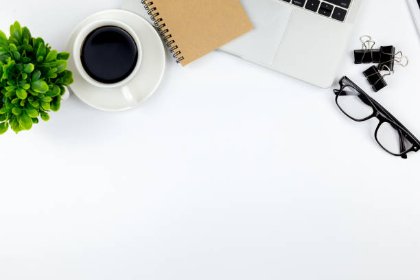 istock Modern white office desk table with laptop computer, smartphone with black screen over a notebook and cup of coffee. 1166815016