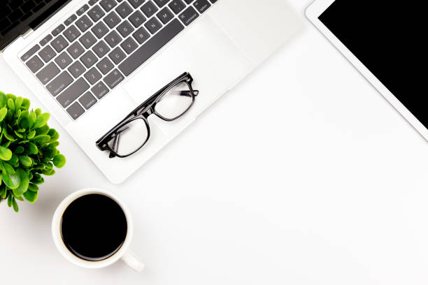 istock Modern white office desk table with laptop computer, smartphone with black screen over a notebook and cup of coffee. 1166815072