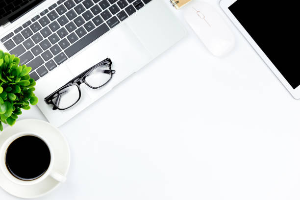 istock Modern white office desk table with laptop computer, smartphone with black screen over a notebook and cup of coffee. 1166815600