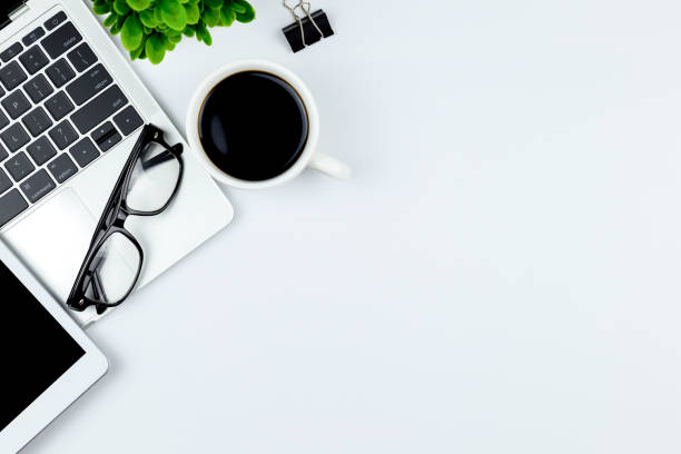 istock Modern white office desk table with laptop computer, smartphone with black screen over a notebook and cup of coffee. 1166815955