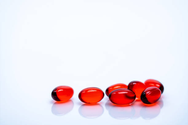 красный мягкий гель капсулы таблетки изолированы на белом фоне. куча красной мягкой желатиновой капсулы. витамины и пищевые добавки концеп - anti aging pill capsule vitamin pill стоковые фото и изображения