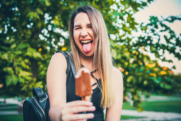 istock Cheerful Young woman holding ice cream 1166818400