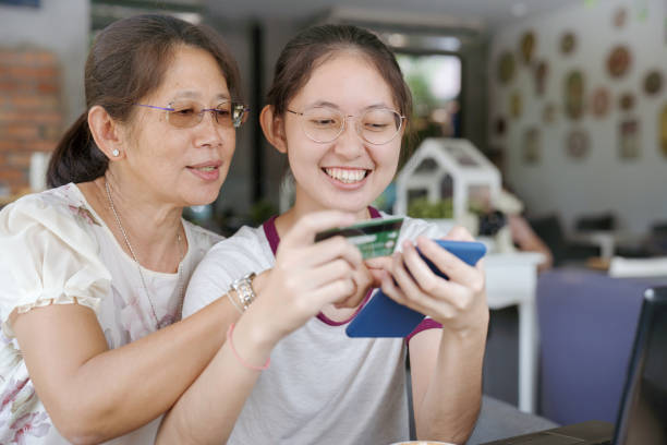 istock Asian  young teenage on vacation relaxing using digital tablet and smart phone for doing homework at home and relax with online game and text message on social network 1166818879
