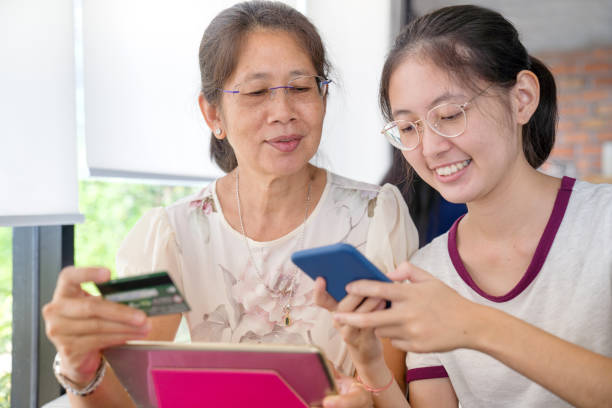istock Asian  young teenage on vacation relaxing using digital tablet and smart phone for doing homework at home and relax with online game and text message on social network 1166818950