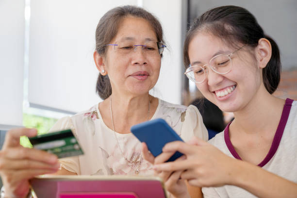 istock Asian  young teenage on vacation relaxing using digital tablet and smart phone for doing homework at home and relax with online game and text message on social network 1166818953