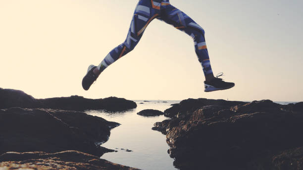 Training on a rocky shore. Epic jump. Close up on legs