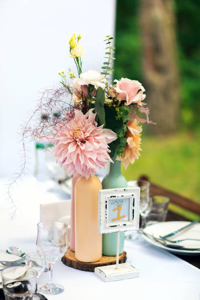 istock Elegant wedding table arrangement, floral decoration with peony, restaurant. Wedding table setup. Wedding in the forest. Seat numbers. 1166821239
