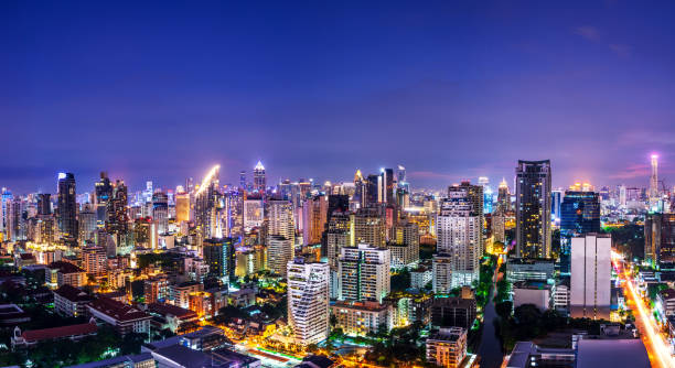 panoramico di metropoli urbana paesaggio urbano notturno sullo skyline crepuscolare e coda di luce di velocità di auto - bangkok thailand skyline night foto e immagini stock