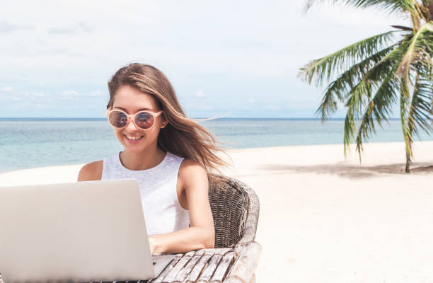 istock Young woman using laptop computer on a beach. Freelance  concept 1166826861