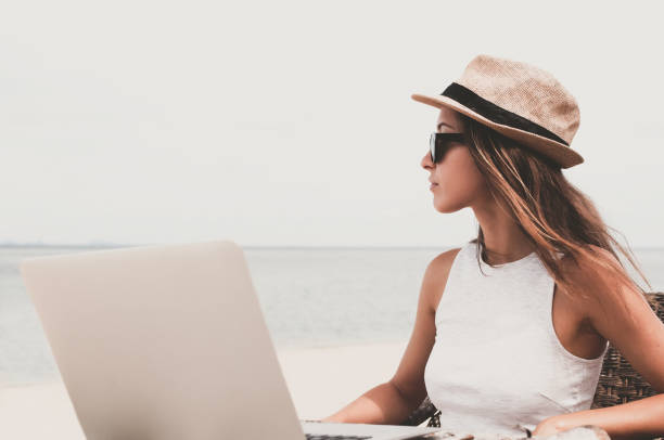 istock Young woman using laptop computer on a beach. Freelance  concept 1166827475