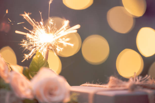 istock Rose flower, gift box, sparkler, on wooden table with bokeh background 1166827661