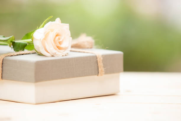 istock Rose flower on wooden table with gift box and copy space 1166827714