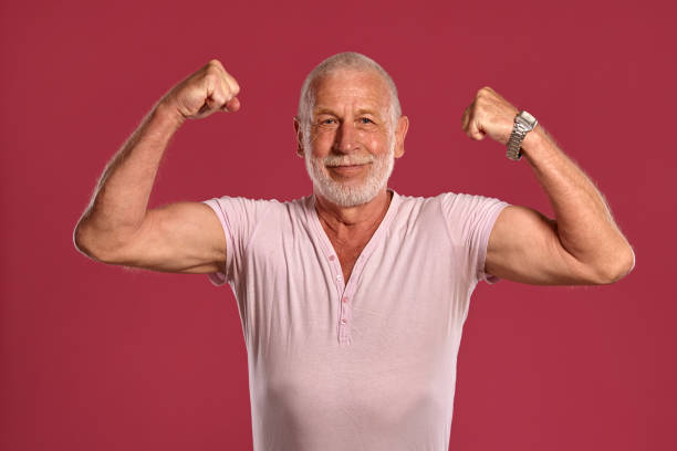 istock Handsome mature man posing against a pink studio background 1166829940