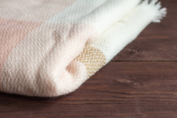 istock Soft and warm folded wool plaid on wooden background 1166835371