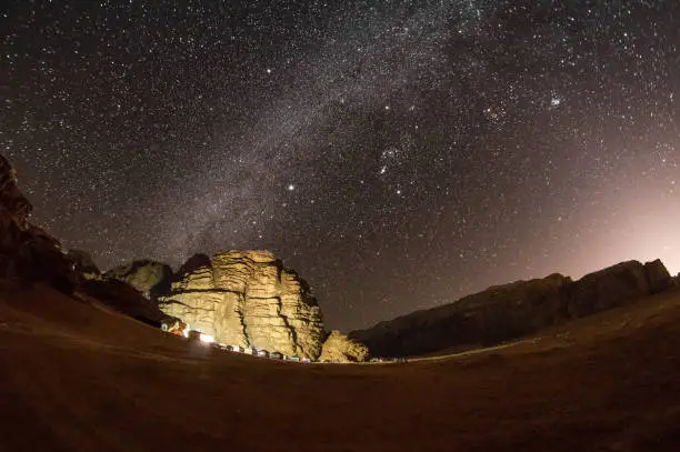 Photo of Stars over landscape and mountains in Wadi Rum in Jordan