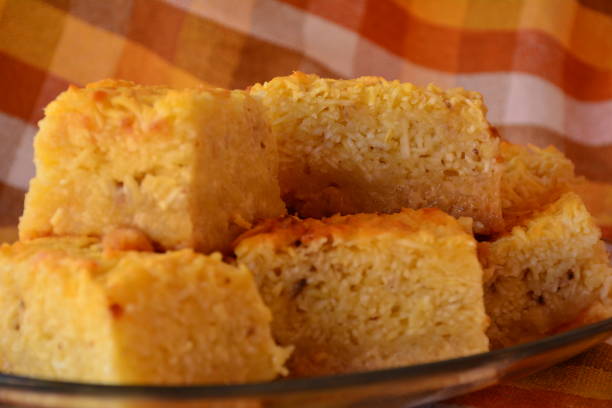 istock mandioca, aipim, macaxeira. Raw grated manioc cake cut into pieces on checkered tablecloth background. 1166839318