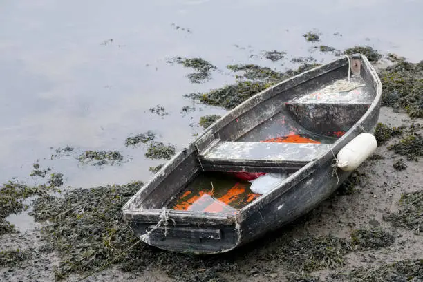 Rustic old boat red wooden moored at harbour uk