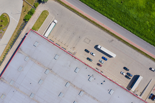 Aerial view of goods warehouse. Logistics center in industrial city zone from drone view. Background texture concept.