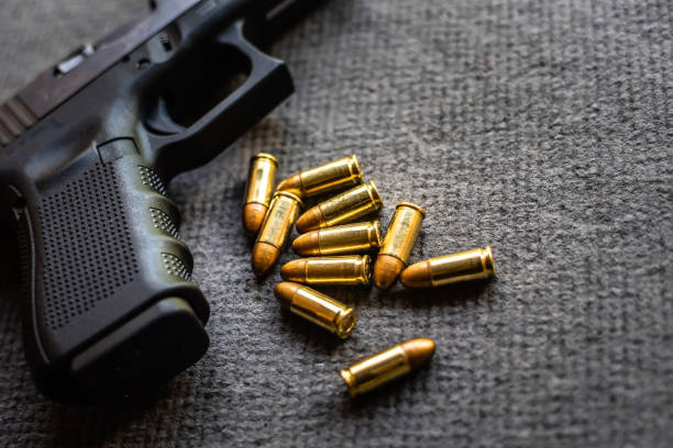 istock bullets and gun on black velvet desk 1166844445