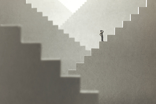 concepto surrealista de un hombre subiendo escaleras para tratar de llegar a la cima photo
