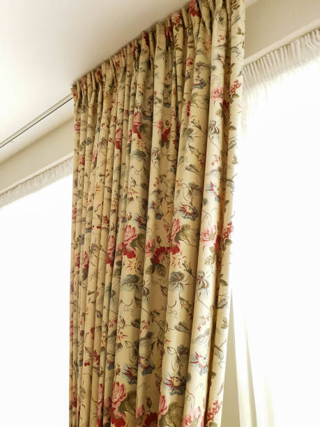 istock Vintage beige curtains hanging on window with colorful pattern in a light room 1166845905
