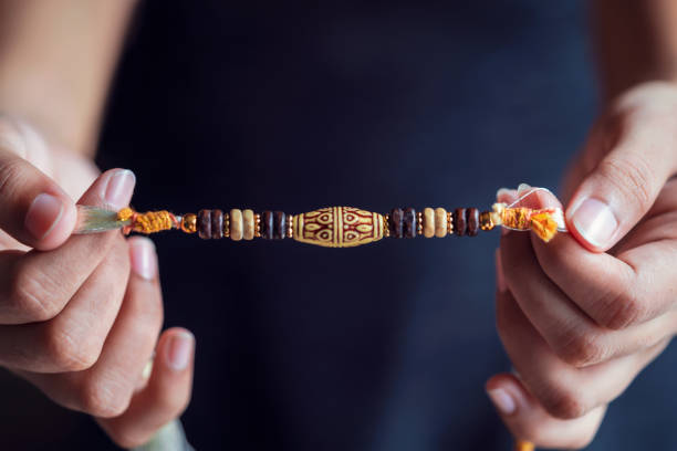 A Person Holding A Beautiful Rakhi A young girl holding a beautiful rakhi for raksha bandhan. Closeup shot for raksha bandhan concept with copy space. rakhi stock pictures, royalty-free photos & images