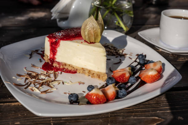 istock classic cheesecake with raspberry jam on a plate decorated with fresh strawberries and cup of coffee 1166849584
