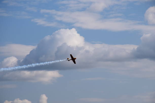 istock A small yellow passenger plane flying quickly and dynamically through the cloudy summer sky while generating some smoke behind the machine and travelling at a high altitude to a set destination 1166849903