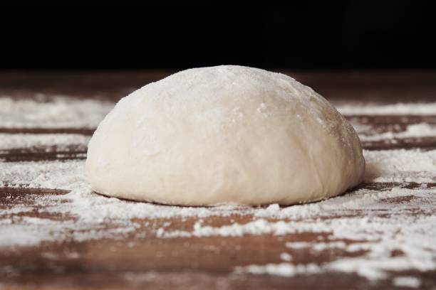 palla di pasta fatta in casa per pizza su tavolo in legno infarinato - dough foto e immagini stock